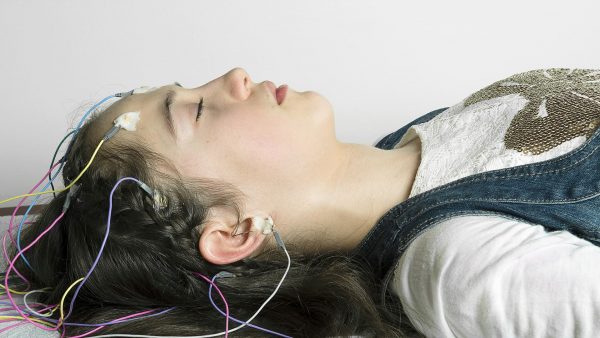 Девушка спит с датчиками ЭЭГ, отслеживающими работу головного мозга