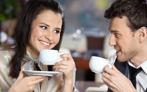 Девушка и молодой человек пьют кофе