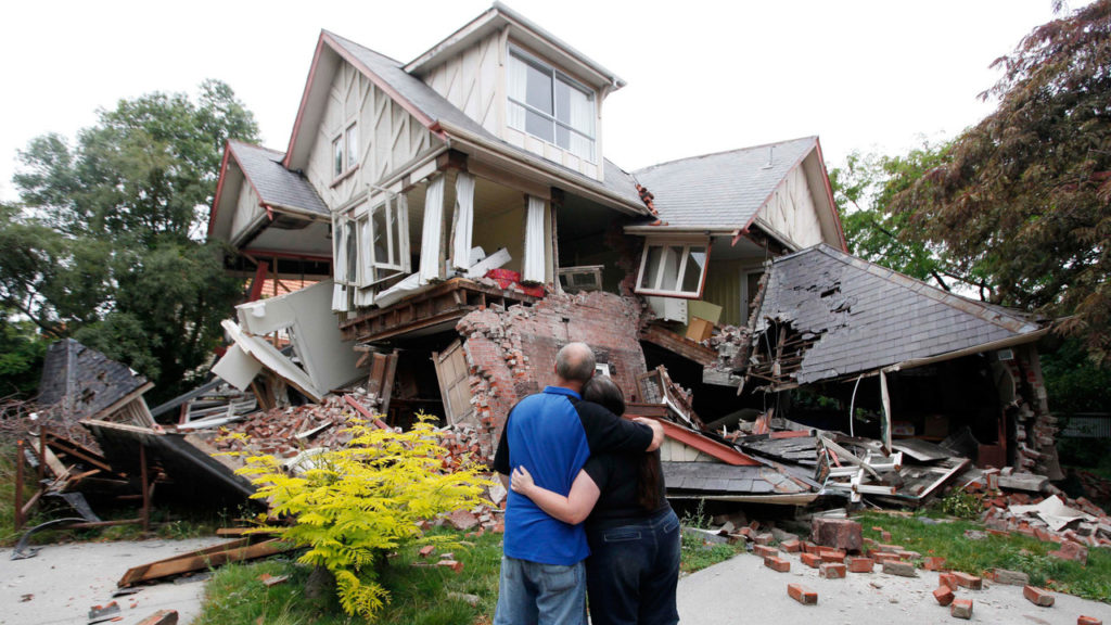 Семейная пара перед рухнувшим домом