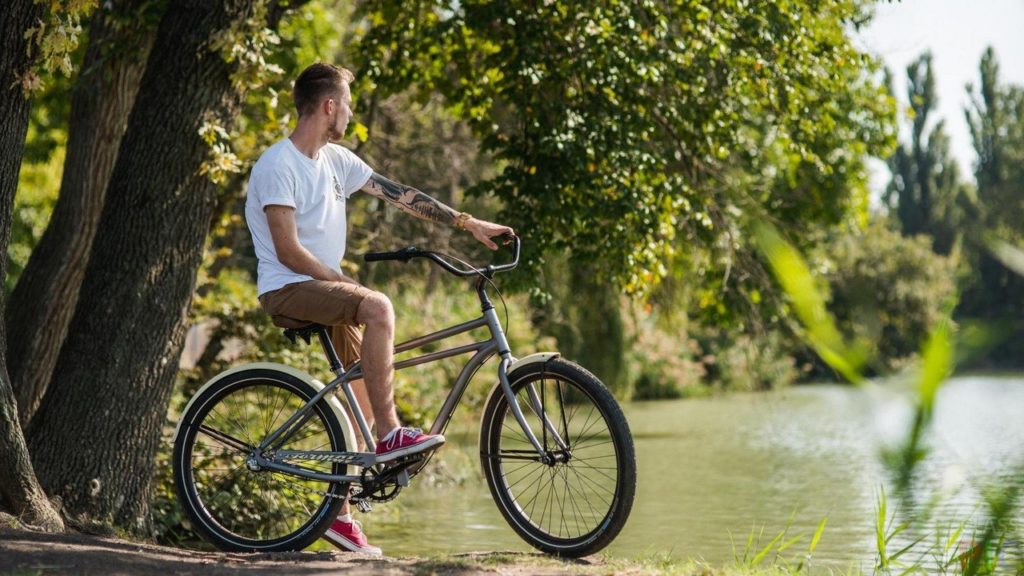 Парень с велосипедом на берегу реки